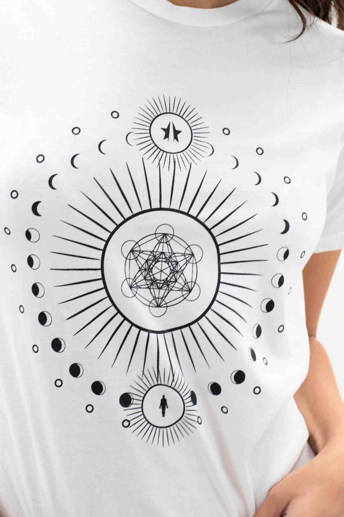 Close-up of a person wearing the Moon Metatron Tee in Lite Beam by GFLApparel, which features a geometric design with sunburst patterns, lunar phases, and circular arrangements of lines and dots, all intricately inspired by Sacred Geometry.